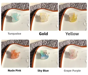 Detail view of small acetate cat hair clips in six pearlescent colors on a white plate