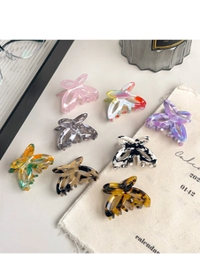 Flat lay of small acetate butterfly hair claws in eight different marble patterns and colors