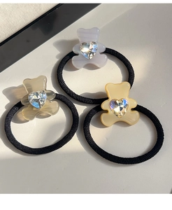 Detailed shot of three bear-shaped elastic hair ties with sparkling heart rhinestones