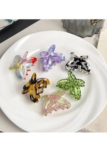 Collection of six acetate butterfly hair claws in various patterns on a white plate