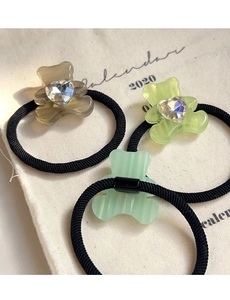 Close-up of three acetate bear hair ties in brown and green with heart-shaped crystals