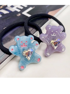 Close-up of cute cartoon bear hair ties in blue and purple with heart crystal details