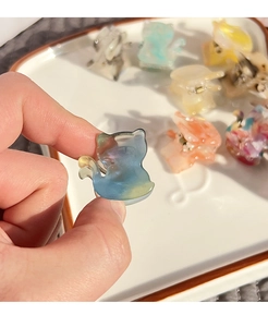 Close-up of mini cat-shaped acetate hair claws showing colorful gradient textures