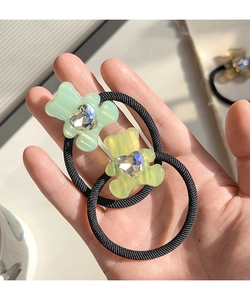 Detail of bear hair ties with mint green and lemon yellow resin bears and heart gems