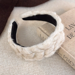 Gros plan détaillé d'un serre-tête beige tissé en peluche avec une texture douce d'hiver