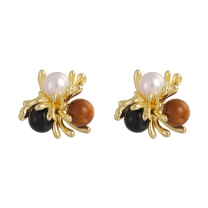 Vintage gold coral branch earrings with white pearl, black and brown beads on white background