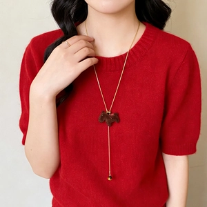 Brown flocked terrier pendant necklace on red knit sweater with gold finish ring