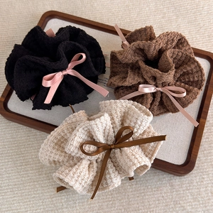 Détail de chouchous gaufrés avec rubans en satin en noir, marron et blanc crème