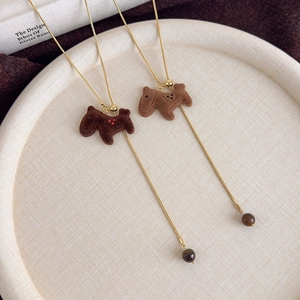 Detailed view of flocked horse pendants with golden chains and beaded accents