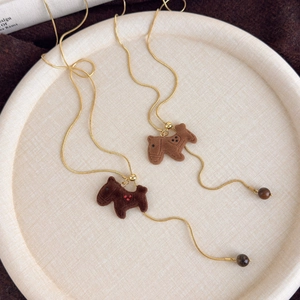 Close-up of brown flocked puppy pendants on gold snake chains with adjustable beads