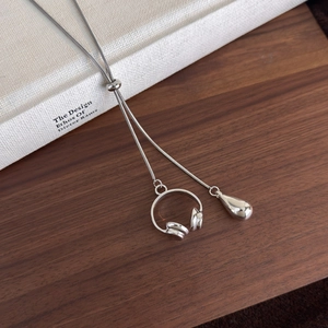 Close-up of silver Y-shaped necklace with headphone and water drop pendants on snake chain