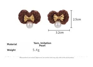 Detail view of woven brown bow earrings with gold accents, pearls, and 3.2cm size marks