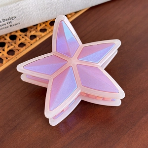 Detalle de la pinza para el pelo con forma de estrella iridiscente en violeta y rosa