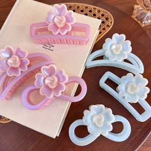 Détails de pinces à cheveux fleuries roses et bleues sur un plateau en bois