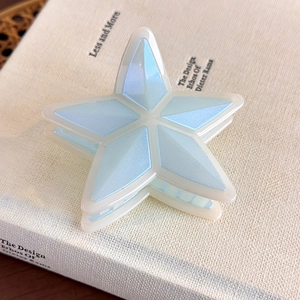 Detalle de pinza para el pelo en forma de estrella con acabado nacarado azul en libro