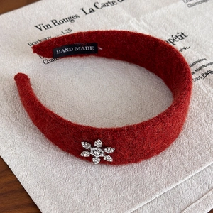 Détail du serre-tête en peluche rouge avec flocon de neige en strass et étiquette faite à la main