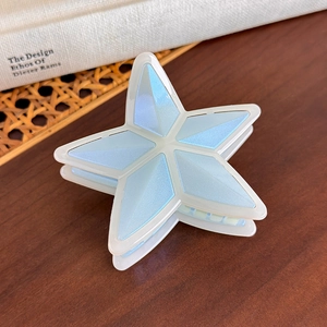 Detalle de la pinza para el cabello en forma de estrella con acabado perlado azul claro