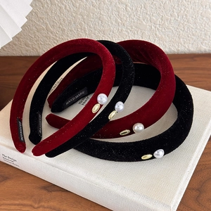 Vintage velvet headbands in red and black with pearl and gold accents on white books