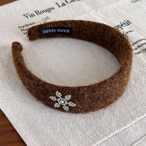 Détail du serre-tête en peluche marron avec flocon de neige en strass et étiquette faite main
