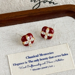 Gros plan de boucles d'oreilles trèfle en émail rouge et zircons blancs étincelants
