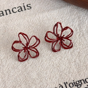 Macro shot of dark red hollow flower studs on beige linen fabric background