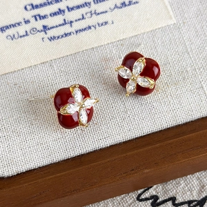 Vue détaillée de boucles d'oreilles trèfle en émail rouge vintage avec zircons