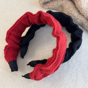Close-up of red and black pleated knit headbands with soft wool texture for women