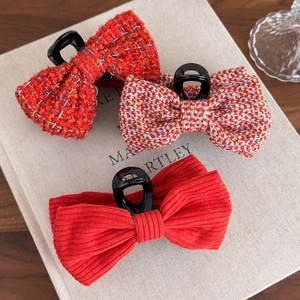 Detail showing red tweed and corduroy bow hair claws on a decorative book background