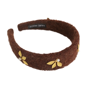 Brown wool wide headband with golden metal leaves and white pearls on white background