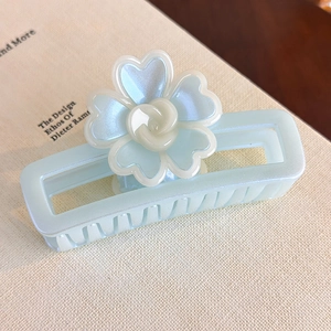 Détail d'une pince à cheveux fleur irisée sur un fond de livre de style vintage