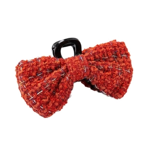 Elegant red tweed bow hair claw clip with golden thread accents on white background