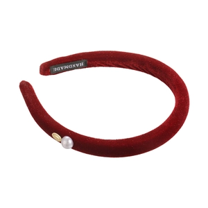 Retro red velvet padded headband with gray pearl and golden metal piece on white background