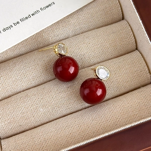 Détails des boucles d'oreilles perles rouges avec zircons sur un coffret cadeau