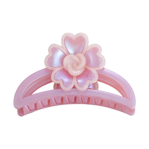 Détail de la pince à cheveux fleur rose avec doubles pétales et finition nacrée élégante