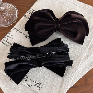 Macro shot of large velvet bow banana hair clips showing soft texture and grip teeth
