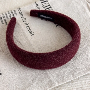 Detail eines burgunderroten Plüsch Stirnbands mit weicher Textur und handgefertigtem Etikett