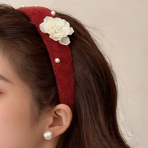 Detailed view of a red wool headband featuring a white lace flower and delicate pearls