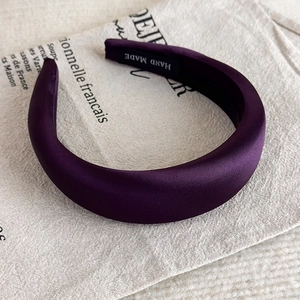 Detailaufnahme des handgefertigten lila gepolsterten Satin Stirnbands mit hohem Design