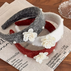 Detailed texture of tweed headbands with white pearls and camellia fabric flowers