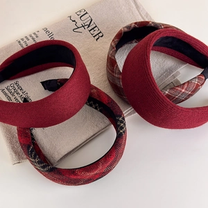 Detail of four retro plaid and solid burgundy wide headbands on vintage linen fabric