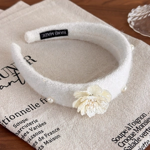 Detail of white wool headband with camellia flower and pearls for elegant styling