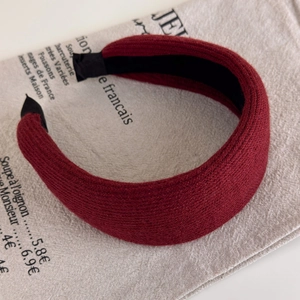Detailed view of burgundy ribbed knit headband with non-slip lining on vintage linen