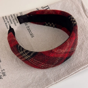 Detail of red and black plaid sponge headband showing thick wool-like texture on linen