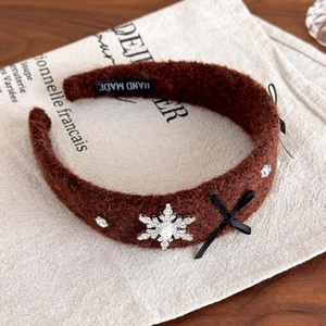 Detail of winter snowflake headband with rhinestone pearls and handmade label