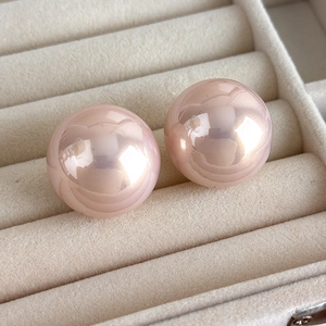 Macro shot of 25mm pink Baroque pearls with high mirror luster in a beige velvet jewelry box