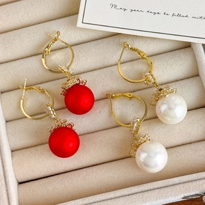 Detail of red and white pearl hoop earrings with gold-plated metal and diamonds