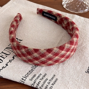 Detail of handmade vintage red checkered headband on aesthetic linen background