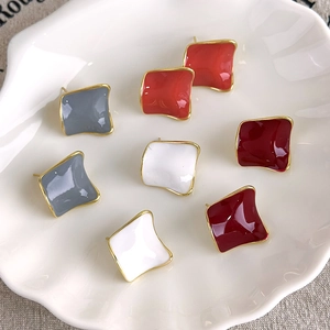 Minimalist square stud earrings with colorful enamel glaze on a white shell tray