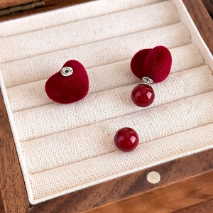 Dettaglio degli orecchini a cuore floccato bordeaux con perla in scatola di legno