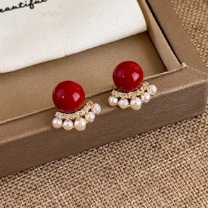 Elegant red bead earrings with pearls and crystals displayed on a jewelry box